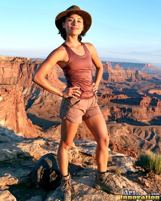 Woman in a sun hat and hiking boots on an upper canyon rim
