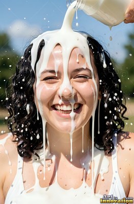 A laughing woman ends up plain white milk poured straight over her dark hair in the sun