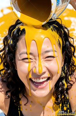 A cheerful woman getting yellow paint poured on her head