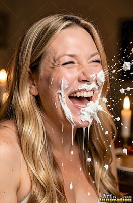 Head tilted back at a table, a laughing woman gets hit with white cream
