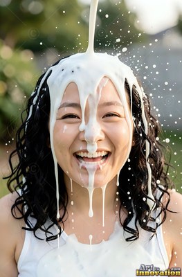 A woman with a smile has splashing white milk poured over her head in bright outdoor light