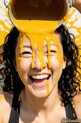 A smiling woman gets yellow paint poured on her face