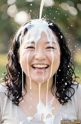 A smiling woman with plain white milk splashing on her head