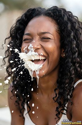 Cheerful woman with long curly hair gets splashed in the mouth with milk