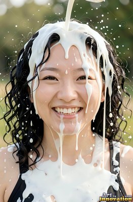 In a sunny park, a smiling woman gets thick white milk poured over her head