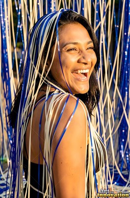 Woman laughing with blue and white streamers draped over her head