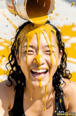 A smiling woman in a black tank top gets thick yellow paint dumped on her head outdoors in bright sun