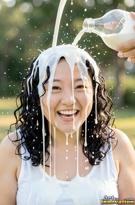 Dark curly hair frames a woman laughing outdoors in sunlight as milk is poured on her head