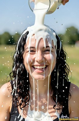Curly black hair frames a smiling woman in a sunny field as splashing white milk pours over her head