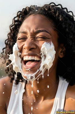 A woman laughing finds herself hit in the face with white cream under bright sunlight