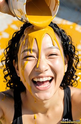 Laughing in the sun, a woman has yellow paint poured over her dark hair