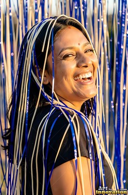 Smiling woman covered in blue and white streamers outdoors