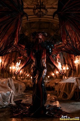 In a dark ballroom, a horned woman with large wings holds fire in both hands