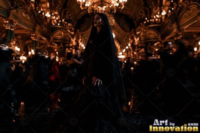 A pale-skinned woman in a long black veil stands in a dark, candlelit ballroom
