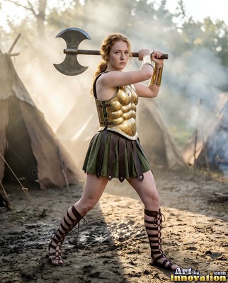 Woman in a golden breastplate holds a heavy battle axe in camp