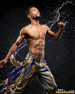 Dancing shirtless, a man twists as gold and blue water splashes past him in the dark studio
