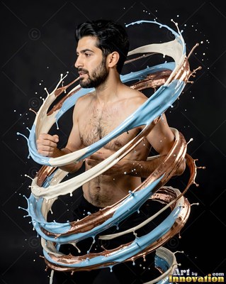 Turn ed sideways in a studio, a shirtless man is encircled by swirling paint loops