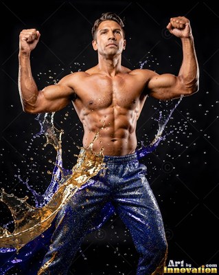 A shirtless man flexes his arms as gold and blue water splashes past his waist
