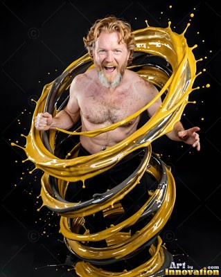 A shirtless man shouts as thick yellow paint spirals around him in bright studio light