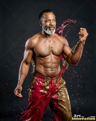 A shirtless older man poses as red and gold water splashes around him