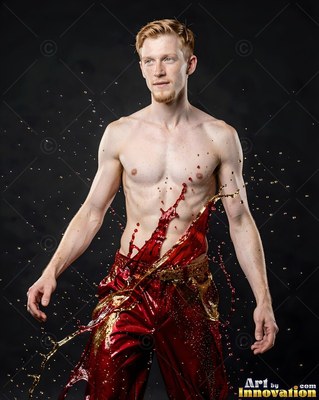 Shirtless man with red liquid splashing across his torso