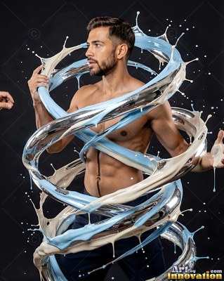 In a dark studio, a shirtless man is encircled by splashes of blue and white liquid