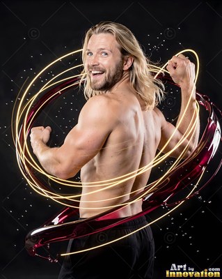 Flexing both arms, a shirtless blond man smiles inside rings of yellow light and red fluid