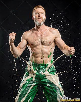 Shirtless man in green pants flexing as white liquid splashes around him