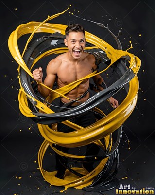 Facing forward in a dark studio, a cheering man is circled by yellow paint ribbons