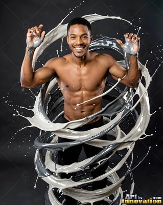 Smiling shirtless man wrapped in swirls of gray and white paint