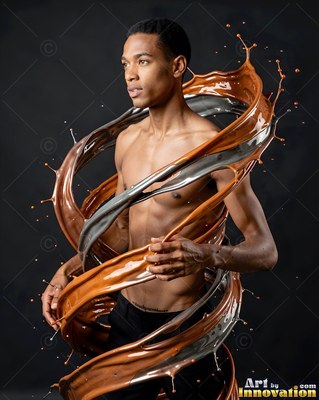 In a dark studio, a shirtless man is encircled by brown and silver liquid splashes