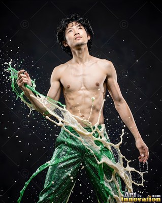 Shirtless man splashed with green and white paint