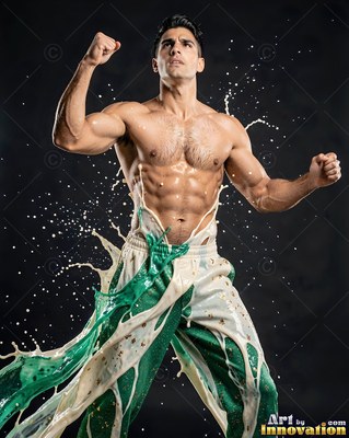 Muscular shirtless man flexing his arms as white and green liquid splashes over his pants