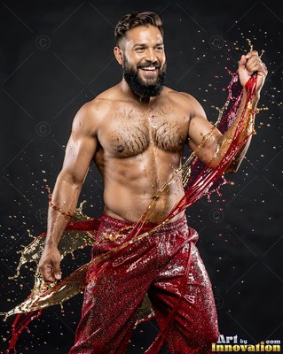 Smiling bearded man splashed with red and gold water