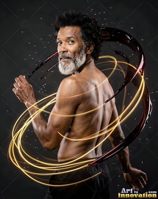 In a dark studio, a shirtless bearded man is encircled by red liquid and light