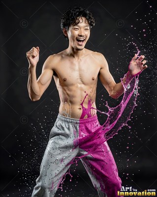 A shirtless man cheers as bright pink liquid splashes across his waist under studio light