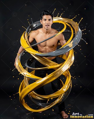 Standing barefoot, a shirtless man is encircled by rings of yellow and gray paint