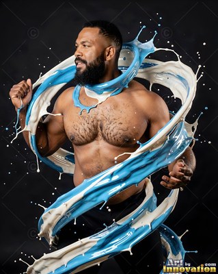 A shirtless bearded man twists as blue and white paint swirls around his torso