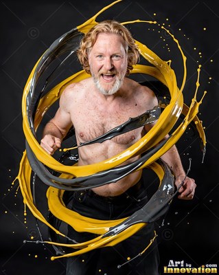 A shirtless man shouts as thick yellow and gray liquid swirls around him in studio light