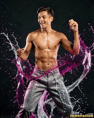 Dancing in a dark studio, a smiling shirtless man with pink and clear water splashes