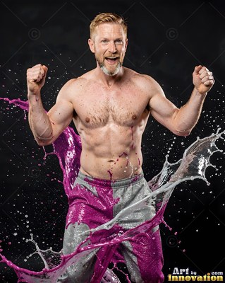 In gray sweatpants, a shirtless man flexes his fists as purple liquid splashes by him