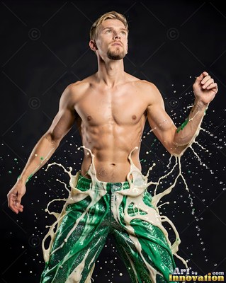 Shirtless man wearing green pants with splashing white liquid