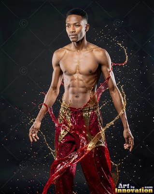 A shirtless man stands as red and gold liquid splashes around his waist under soft light