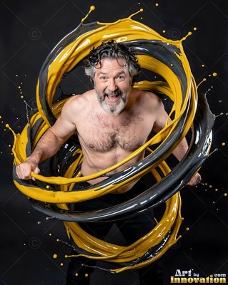 A smiling shirtless man circled by splashes of yellow and gray paint