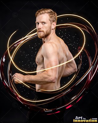 A shirtless bearded man stands inside swirling loops of yellow and red liquid