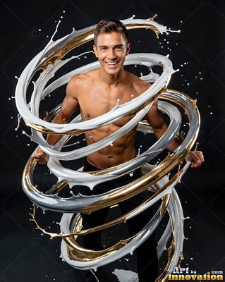 In a dark studio, a smiling shirtless man is encircled by white and gold paint splashes