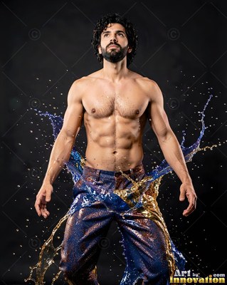 A shirtless man poses as blue and gold liquid splashes from his patterned pants
