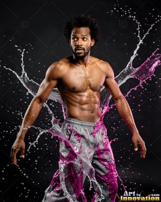 In a dark studio, a shirtless man is hit by clear water and pink liquid