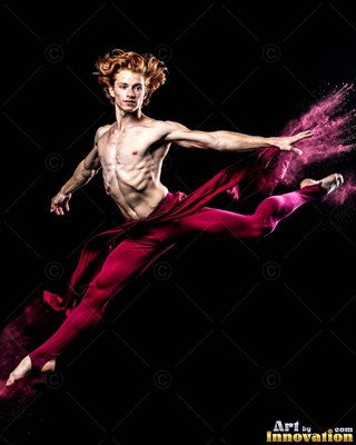 A shirtless man in red tights leaps through pink powder against a black backdrop