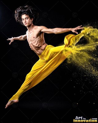 Man leaps in yellow pants kicking up yellow powder